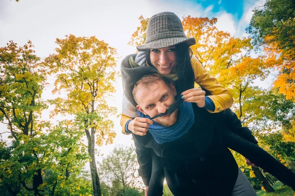 Couple heureux s'amuser à Autumn Park. Feuilles et arbres jaunes. Riant homme et femme en plein air. Concept de liberté . — Photo
