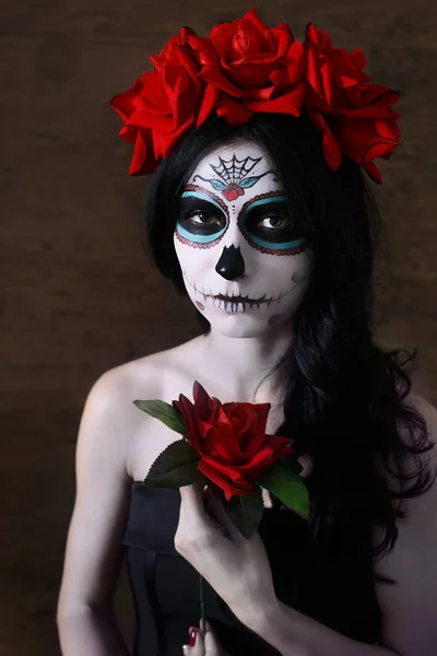 Il giorno dei morti. Halloween. La giovane donna in giorno della maschera morta il cranio affronta l'arte e è salita. Sfondo scuro . — Foto Stock