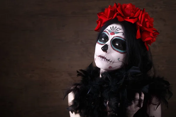 El día de los muertos. Halloween. Mujer joven en el día de la máscara muerta cráneo cara arte y rosa. Fondo oscuro . —  Fotos de Stock