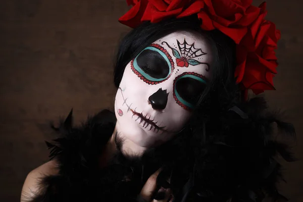 死亡日。万圣节.年轻的女人在死去的面具骷髅脸上画着玫瑰。深色背景. — 图库照片