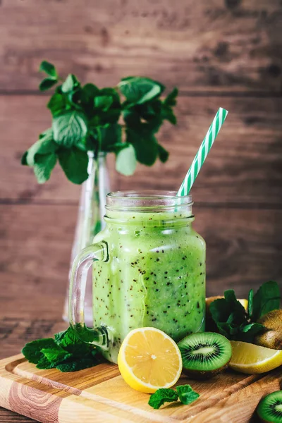 Delicious kiwi smoothie with mint in mason jar on table against dark wooden background. Healthy lifestyle concept — Stock Photo, Image