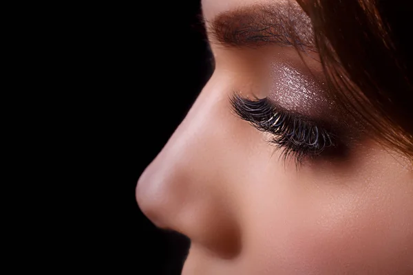 Eyelash Extension Procedure (engelsk). Kvinnelig øye med lange øyevipper etter forlengelsesprosedyren. Hvite øyevipper. Mørk bakgrunn. Sminke. Nært, selektivt fokus . – stockfoto