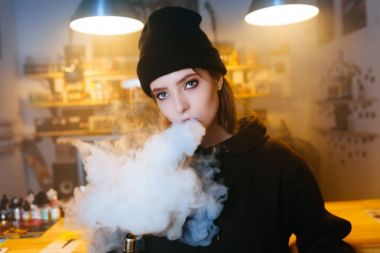 Vaping kız. Genç hipster kadın vape e-cig vapeshop. Hip-hop tarzı. Portre.