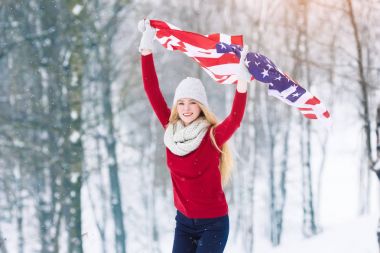ABD bayrağı ile genç genç kız kış portresi. Güzellik gülen ve having fun kış Park geniş neşeli modeli kız. Açık havada güzel genç kadın. Zevk doğa, kış