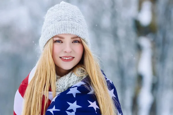 Ritratto invernale di una giovane adolescente con bandiera USA. Bellezza Gioioso Modello Ragazza ridere e divertirsi nel parco invernale. Bella giovane donna all'aperto. Godersi la natura, l'inverno — Foto Stock