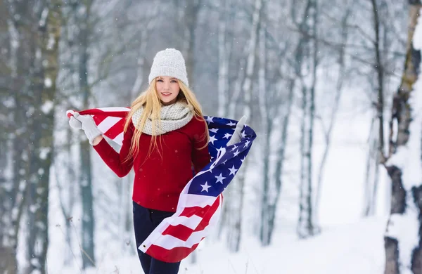 Ritratto invernale di una giovane adolescente con bandiera USA. Bellezza Gioioso Modello Ragazza ridere e divertirsi nel parco invernale. Bella giovane donna all'aperto. Godersi la natura, l'inverno — Foto Stock