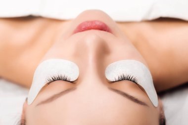 Kirpik uzatma prosedürü. Uzun kirpikli kadın gözü. Yaklaş, seçici odaklanma.