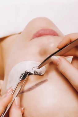 Kirpik uzatma prosedürü. Uzun kirpikli kadın gözü. Yaklaş, seçici odaklanma.