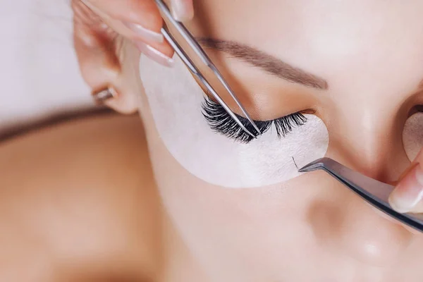 Eyelash Extension Procedure. Woman Eye with Long Eyelashes. Close up, selective focus. — Stock Photo, Image