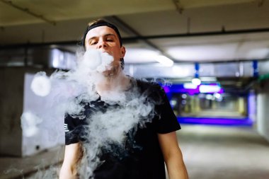 Şapkalı adam sigara elektronik sigara ve bültenleri bulutlar vaping hileler çeşitli tür performans buharı