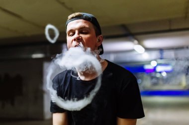 Şapkalı adam sigara elektronik sigara ve bültenleri bulutlar vaping hileler çeşitli tür performans buharı