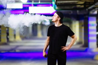 Şapkalı adam sigara elektronik sigara ve bültenleri bulutlar vaping hileler çeşitli tür performans buharı