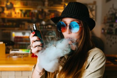 Vaping kız. Genç hipster kadın vape e-cig vapeshop. Hip-hop tarzı. Portre.