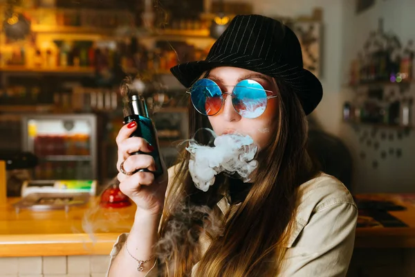 Vaping lány. Fiatal csípő nő vape e-cigi, az vapeshop. Hip-hop stílusban. Vértes. — Stock Fotó