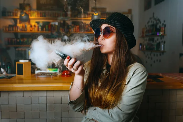 Vaping kız. Genç hipster kadın vape e-cig vapeshop. Hip-hop tarzı. Portre.