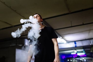 Şapkalı adam sigara elektronik sigara ve bültenleri bulutlar vaping hileler çeşitli tür performans buharı