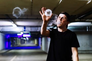 Şapkalı adam sigara elektronik sigara ve bültenleri bulutlar vaping hileler çeşitli tür performans buharı