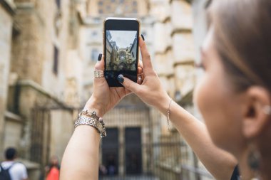 Kız telefonda fotoğraf ya da video çekiyor. Eller akıllı telefonu tutsun ve Avrupa 'nın eski kasabasında bir fotoğraf çeksin. Toledo, İspanya