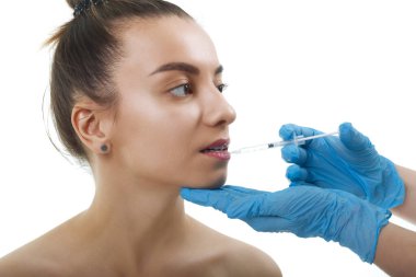 Yüz Güzelliği Enjeksiyonları. Portre Güzel Genç Kadın Hyaluronic Asit Enjeksiyonu alıyor. Eldivenli Ellerin Yakın Çekici Kadın Yüzü Şırıngası Tutuşu.
