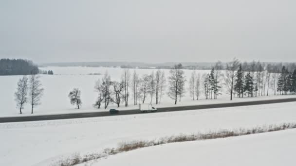 Delivery van drive on winter country road, air view from drone in 4k. Слідкуючий постріл. Визволи все за будь-якої погоди. Полегшення концепції. — стокове відео