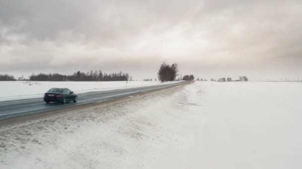 Автомобиль едет по зимней проселочной дороге, вид с воздуха с дрона в 4к. Главная рамка ввода объекта . — стоковое видео