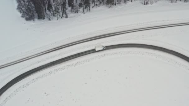 Delivery van drive on winter country road, air view from drone in 4k. Слідкуючий постріл. Визволи все за будь-якої погоди. Полегшення концепції. — стокове відео