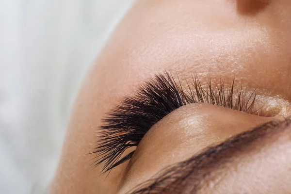 Procedimento de extensão das pestanas. Olho de mulher com pestanas azuis longas. Efeito Ombre. Close up, foco seletivo . — Fotografia de Stock