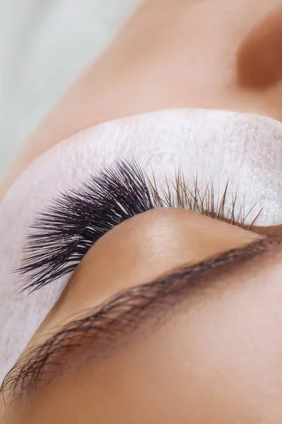 Procedimiento de extensión de pestañas. Ojo de mujer con pestañas largas y azules. Efecto Ombre. Primer plano, enfoque selectivo . — Foto de Stock