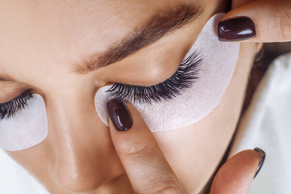 Eyelash Extension Procedure. Woman Eye with Long Blue Eyelashes. Ombre effect. Close up, selective focus.