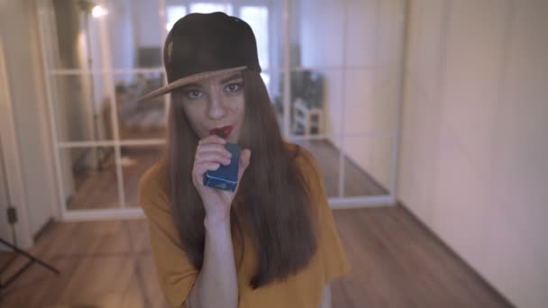 Rapariga vacilante. Jovem hipster mulher vape e-cig no vapeshop. Estilo hip-hop. Fechar. . — Vídeo de Stock