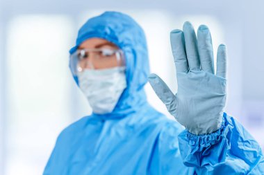 Koronavirüs karantinası kavramı. Çin 'den gelen küresel koronavirüs salgını kavramı. Koronavirüs enfeksiyonu tedavisi. Koruyucu giysili doktor Corona virüsünü durdurmak için el hareketi yaptı.
