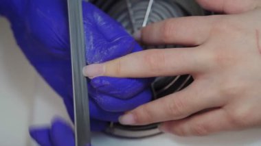 Güzellik salonunda manikür yaptıran bir kadın. Tırnak törpüsü takan bir güzellik uzmanı. Tırnak manikürü yaptıran kadın. Güzellik uzmanı müşteriye çivi çakıyor. Güzellik salonunda manikür süreci.