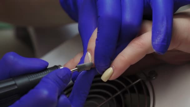 Vrouwelijke manicure meester verwijdert oude gel van klanten nagels. Sluit maar af. Elektrische Nagelboor in Manicure Salon. Hardware manicure in een schoonheidssalon. Zuigrooster. — Stockvideo