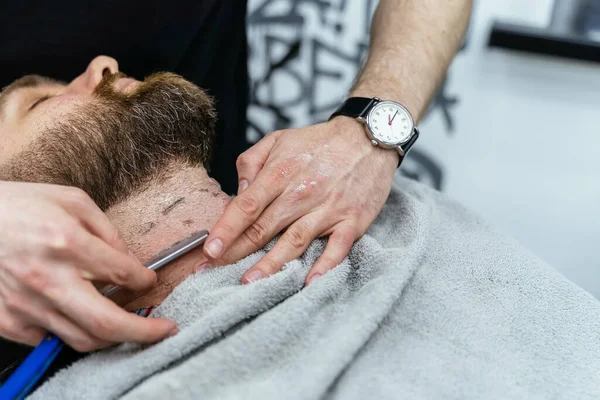 Rasierprozess der Bärte im Barbershop. Nahaufnahme von Friseur macht einen Haarschnitt Bart Client mit Rasiermesser. — Stockfoto