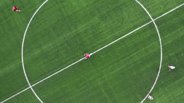 Letecký pohled shora dolů na fotbalové hřiště. Začátek hry. Dva týmy hrají fotbal venku. Výstřel přes hlavu. — Stock video