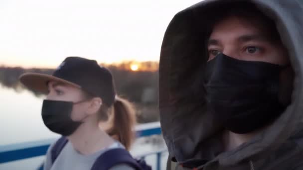 Paar, das in medizinischen Masken auf dem Gesicht die Straße entlangläuft. Menschen mit chirurgischen Gesichtsmasken während des SARS-ConV-2-Konzepts, COVID-19 Coronavirus-Pandemie. Selfie-Aufnahme, — Stockvideo