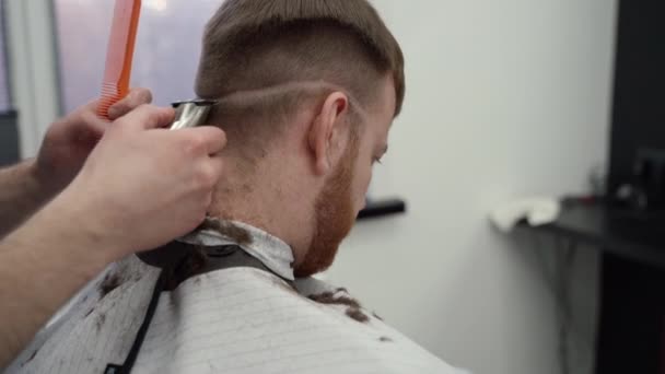 Corte de cabelo masculino com lâmina elétrica. Close up de penteado aparador de cabelo. Barbeiro faz corte de cabelo para o cliente na barbearia usando hairclipper. Cabeleireiro homem com barbeador elétrico. Um tiro à mão. 4K . — Vídeo de Stock