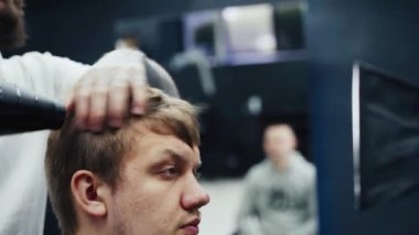 Berber kuaförde erkek saçını kurutuyor. El kamerasıyla. 4K.