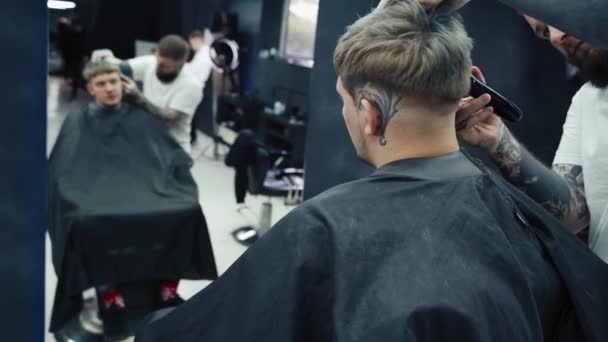 Männlicher Haarschnitt mit Rasiermesser. Nahaufnahme der Frisur des Haarschneiders. Friseur schneidet Kunden im Friseursalon mit Haarschneidemaschine. Mann frisiert mit Elektrorasierer. Handschuss. 4K. — Stockvideo