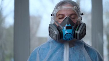 Coronavirus salgını sırasında koruyucu kıyafet giyen kadın portresi. Tehlikeli giysi, solunum maskesi, eldivenler ve gözlük kliniği ya da hastane. Koronavirüsten korunma, covid-19 salgını.