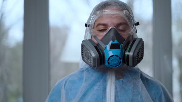 女性医師の肖像コロナウイルスのパンデミックの間に保護服を着て,.ハザードスーツ、呼吸マスク、手袋や眼鏡クリニックや病院。コロナウイルスからの保護, covid-19流行 — ストック動画