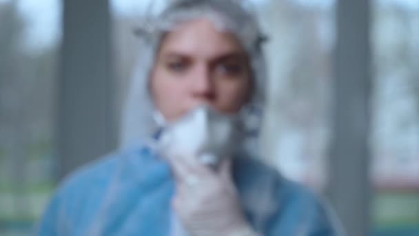 Portrait d'une femme médecin portant une combinaison protectrice pendant une pandémie de coronavirus, d'un médecin en costume de danger, d'un masque respiratoire, d'une clinique de gants et de lunettes ou d'un hôpital. Protection contre le coronavirus, covid-19 — Video