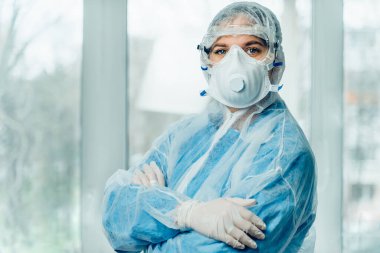 Coronavirus salgını sırasında koruyucu kıyafet giyen kadın portresi. Tehlikeli giysi, solunum maskesi, eldivenler ve gözlük kliniği ya da hastane. Koronavirüsten korunma, covid-19 salgını.