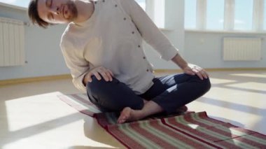 Adam yoga yapıyor. Genç ve çekici erkek nefes egzersizleri yapıyor. Adam salgın sırasında evde meditasyon yapıyormuş. İzolasyon için dinlenme ve dinlenme konsepti. Kaydırma atışı.