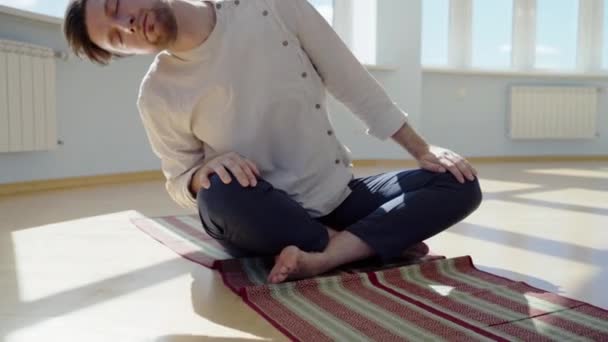 Muž cvičí jógu. Mladý atraktivní muž cvičí dýchání. Chlápek meditující doma během pandemie. Relaxační a odpočinkový koncept pro izolaci. Snímek. — Stock video