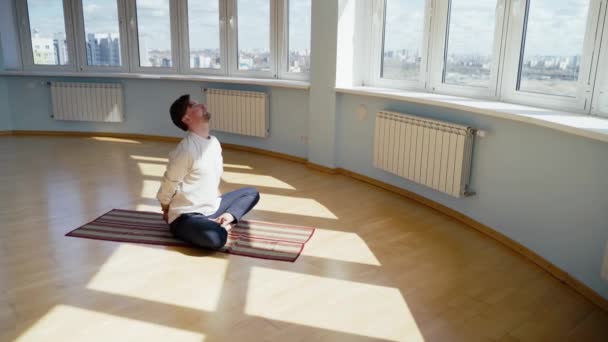 Homem praticar ioga. Jovem atraente masculino fazendo exercícios respiratórios. Um tipo a meditar em casa durante a pandemia. Conceito de relaxamento e repouso para isolamento . — Vídeo de Stock