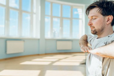 Adam yoga yapıyor. Genç ve çekici erkek nefes egzersizleri yapıyor. Adam salgın sırasında evde meditasyon yapıyormuş. İzolasyon için dinlenme ve dinlenme konsepti. Kaydırma atışı.