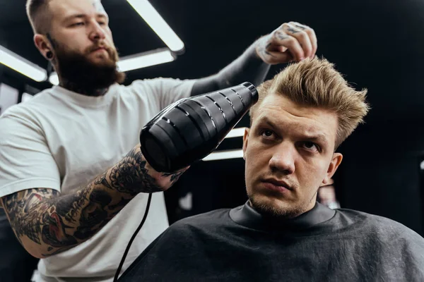 Friseur trocknet männliche Haare im Friseursalon — Stockfoto