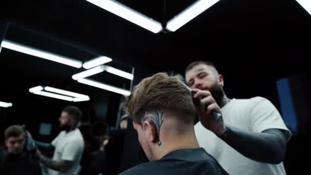 Barber suší mužské vlasy v kadeřnickém salónu. Ruční střelba. 4K. — Stock video