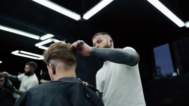 Berber kuaförde erkek saçını kurutuyor. El kamerasıyla. 4K.